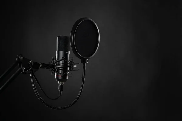 Siyah arka planda izole edilmiş proffesional stüdyo mikrofonu. Podcastlar ve müzik kayıtları.