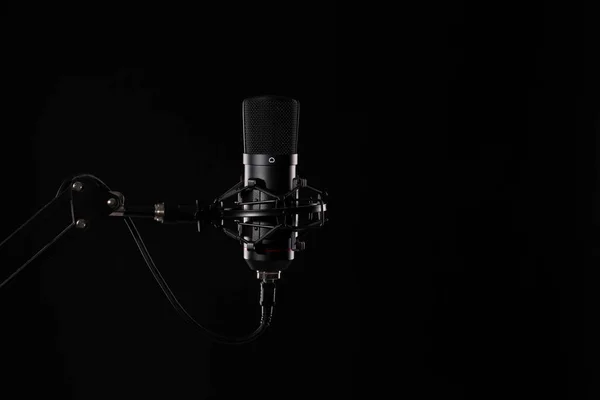 Siyah arka planda izole edilmiş proffesional stüdyo mikrofonu. Podcastlar ve müzik kayıtları.