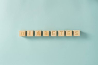 Mavi arkaplandaki tahta küplerle ilgili DIABETES sözcüğü, bloklar tarafından yapılmış işaret