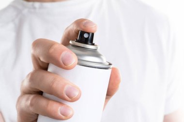 Adamın eli beyaz arka planda izole edilmiş bir kutu aerozol tutuyor.