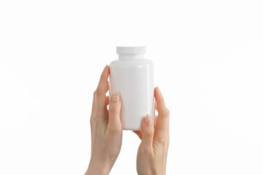 Kadının elinde beyaz bir şişe ilaç hapı, vitamin ya da takviye bezi tutarken ki görüntüsünü kapat..