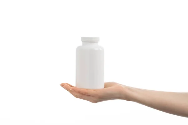 Kadının elinde beyaz bir şişe ilaç hapı, vitamin ya da takviye bezi tutarken ki görüntüsünü kapat..