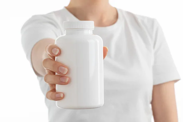 Kadının elinde beyaz bir şişe ilaç hapı, vitamin ya da takviye bezi tutarken ki görüntüsünü kapat..