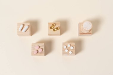 Bej arka planda tahta küplere yerleştirilmiş haplar.