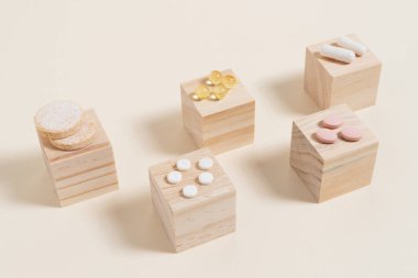 Bej arka planda tahta küplere yerleştirilmiş haplar.