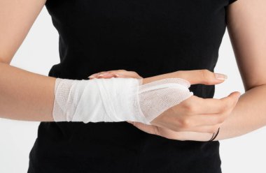 Yaralı eline sarılı sargı bezi olan genç bir kadın..