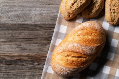 Mutfak bezinde taze ekmek ve yanında kepekli çörekler. Her şeyi ahşap masaya koyun. Fırın, fırın konsepti.