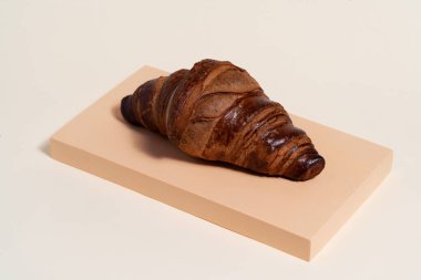Bej arka planda taze pişmiş Fransız kruvasanı. Çok lezzetli kruvasan yemek için hazır..