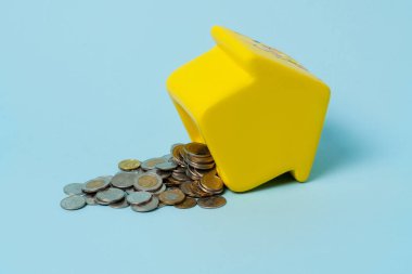 Her yere bir sürü bozuk para saçılmış sarı domuz kumbarası. 