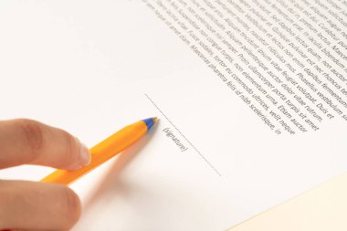 Close up picture of woman's hand singing the document with 