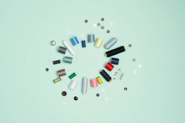 Yeşile dizilmiş bir sürü renkli iplik makarası. 