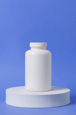 Beyaz bloklardaki ilaç şişesinin fotoğrafını çek. Renkli arkaplanda boş etiketli şişe.