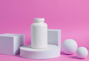 Medication bottle with blank label stacked on white blocks on the colorful background.