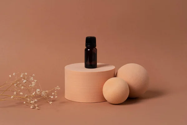 Renkli arka planda görünen geometrik figüre aromatik yağ ya da serum katılmış cam bir şişe. Boş etiketli şişe.