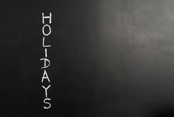Image of chalk board with HOLIDAYS sign. Chalk board background.