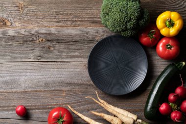 Cintage ahşap masada dekoratif tabakla sergilenen taze sebzeler. Yemek hazırlığı.