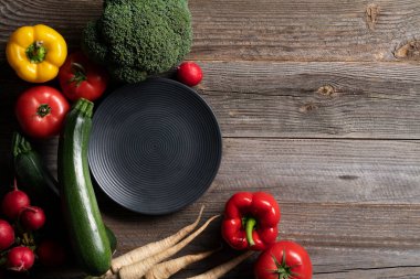 Cintage ahşap masada dekoratif tabakla sergilenen taze sebzeler. Yemek hazırlığı.