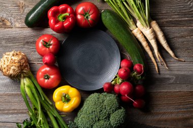 Cintage ahşap masada dekoratif tabakla sergilenen taze sebzeler. Yemek hazırlığı.