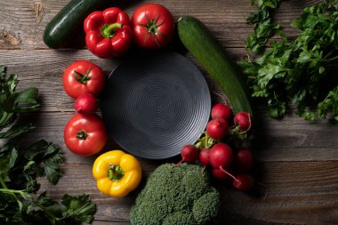 Cintage ahşap masada dekoratif tabakla sergilenen taze sebzeler. Yemek hazırlığı.