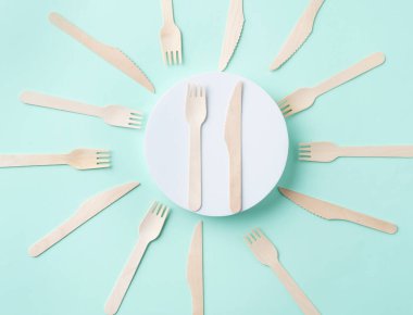 Yeşil arka planda ahşap çatal bıçak takımı. Çevre dostu masa. 