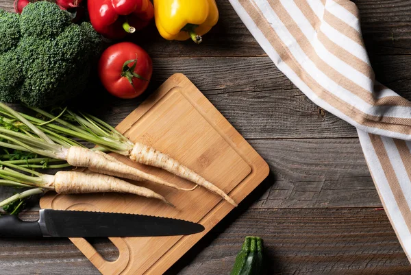 Bir sürü taze sebze, Frocery çiftliğindeki eski ahşap masada doğranmış tahtalarla ortaya çıktı. Yemek ya da salata için hazırlanılıyor.