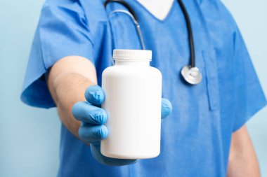 Close up picture of male doctor with stethoskope over neck showing a bottle of pills. No label bottle for product placement.
