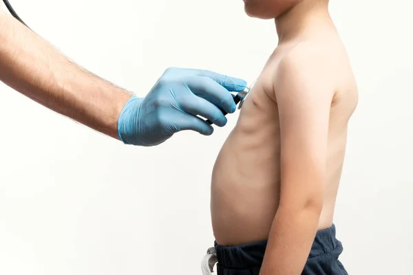 Close up picture of doctor examining a little bou with stethoskope. Boy went to rutinal doctor's check up. Health care concept.