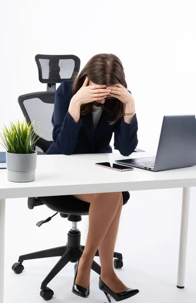 Tired young caucasian bussines woman in her work office. She is tired after long week in job and in a lot of stress because of her responsibilities.