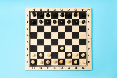 Chess pieces in the playing position on the wooden chess board.