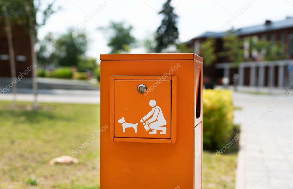 Pet waste station with dog poop bags and garbage in the park 