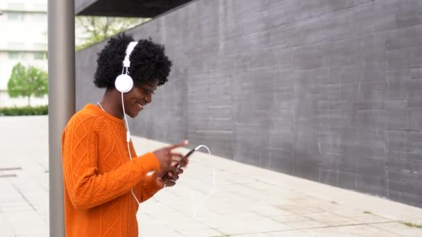 Beztroska Afro American kobieta taniec podczas słuchania muzyki na zewnątrz na ulicy. — Wideo stockowe