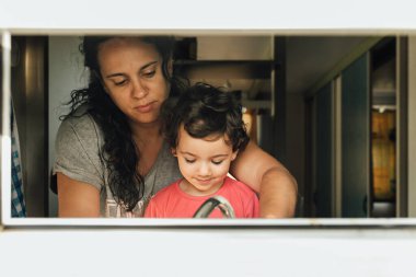 Sevgi dolu bir anne küçük kızına evde bulaşık yıkamayı öğretiyor..