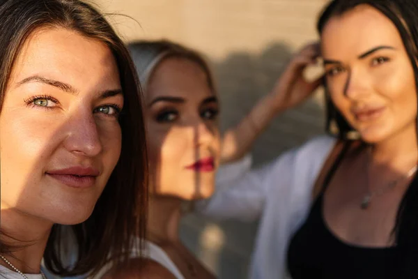 Vue rapprochée de trois femmes regardant la caméra tout en prenant un selfie à l'extérieur. — Photo