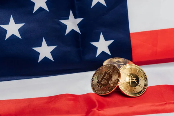 Different cryptocurrency coins on an United States flag.