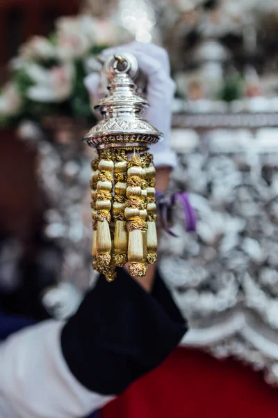 A hand holding a detail of a pomegranate Easter virgin. Easter procession in Granada.