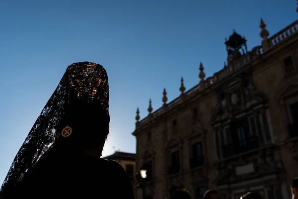 Vista trasera de mujeres religiosas vestidas con mantillas en una procesión católica durante la Semana Santa de Granada, España. — Foto de Stock