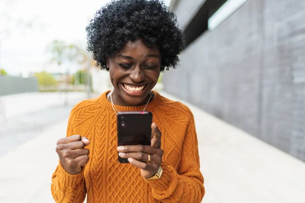 Mulher africana comemorando depois de receber boas notícias em seu telefone celular. — Fotografia de Stock