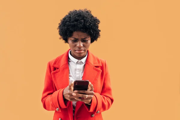 Jovem mulher olhando confuso e preocupado ao ler algo no telefone móvel. — Fotografia de Stock