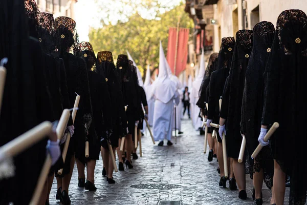 Vista trasera de mujeres religiosas vestidas con mantillas negras en procesión católica durante la Semana Santa de Granada, España. — Foto de Stock