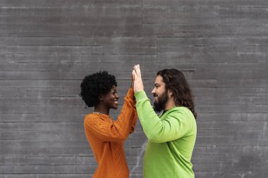 Birbirlerine bakıp, sokakta el ele tutuşan mutlu ırklar arası bir çift. İlişki kavramı.