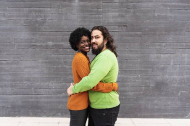 Birbirlerine sarılırken gülümseyen ırklar arası bir çift. İlişki kavramı.