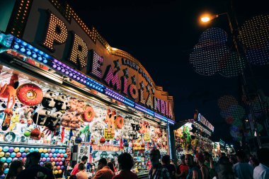 Granada, İspanya, 16 Haziran 2022: İnsanlar lunaparktaki panayır standlarında oynarken eğleniyorlar. Eğlence, tatil ve eğlence konsepti.