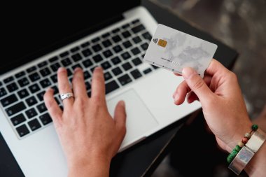 Close up view of a woman shopping online or paying household bills with a credit card and laptop. Online shopping, technology and e-commerce concept.