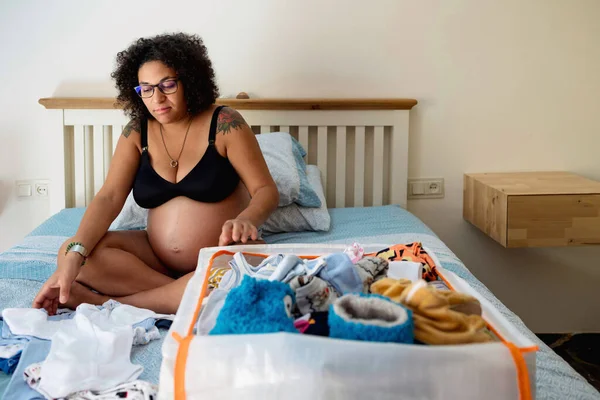 Mulher Grávida Dobrar Preparar Roupas Bebê Enquanto Sentado Cama Casa — Fotografia de Stock