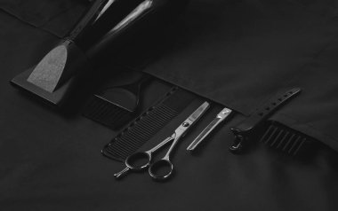 Profesyonel berber aletleri, cepte, siyah stilist önlük, yatay, insan yok.,