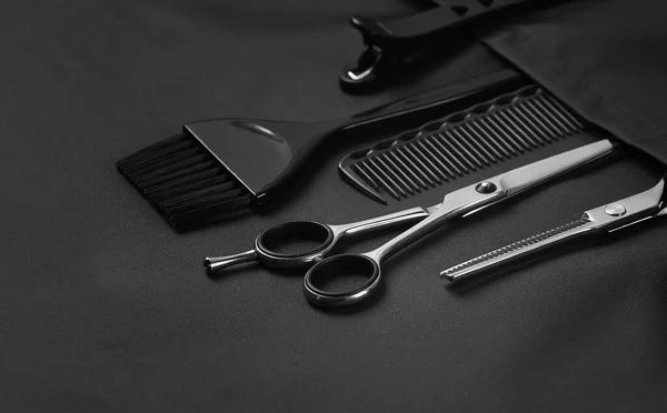 Herramientas profesionales de peluquería, en el bolsillo, delantal estilista negro, horizontal, sin personas, — Foto de Stock