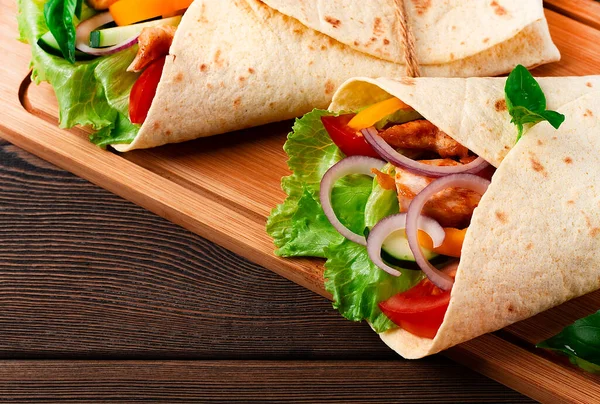 Tortilla avvolge, pollo messicano alla griglia con verdure, burrito, su un tavolo di legno, senza persone, — Foto Stock