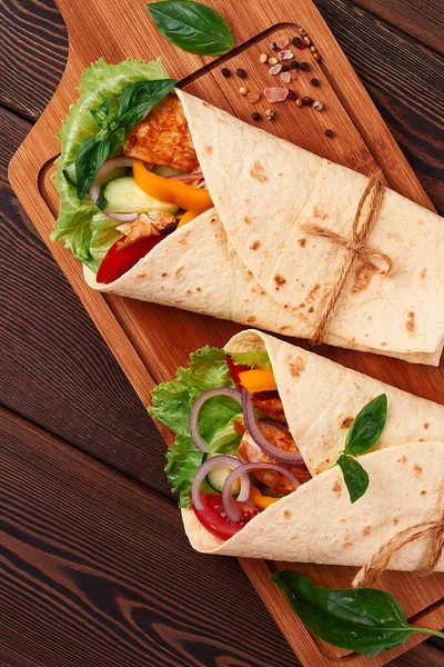 Tortilla avvolge, pollo messicano alla griglia con verdure, burrito, su un tavolo di legno, senza persone, — Foto Stock