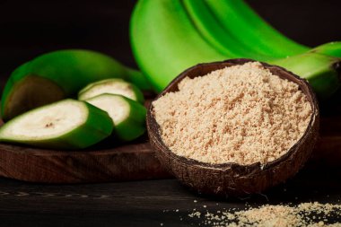 Yeşil muz unu, ahşap bir masada, sağlıklı yiyecekler, seçici odaklanma, köy tarzı, yatay, insan yok, sebze unu, glütensiz, platano muzlar, yeşil muzlar, yaşam tarzı, yemek pişirme,