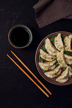 Japon Gyoza hamur tatlısı, soslu, siyah arka planda, üst tarafta, insan yok, tonlanmış, kaynamış,